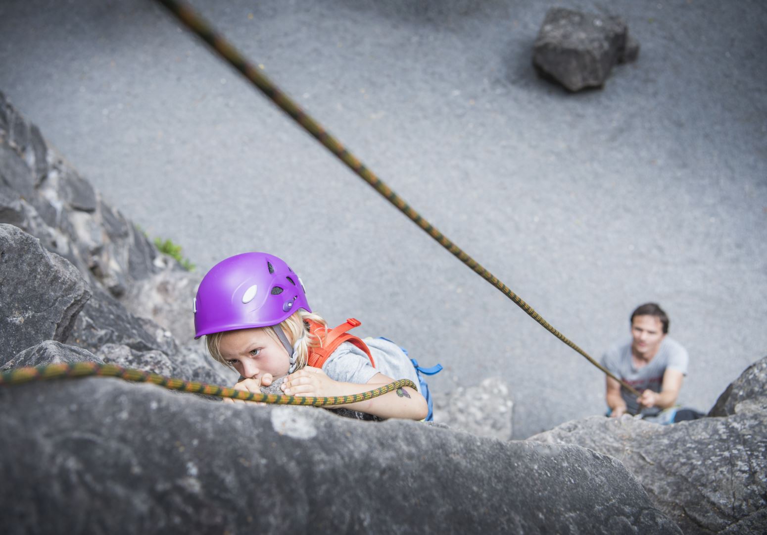 Boy wearing climbing helmet rock climbing