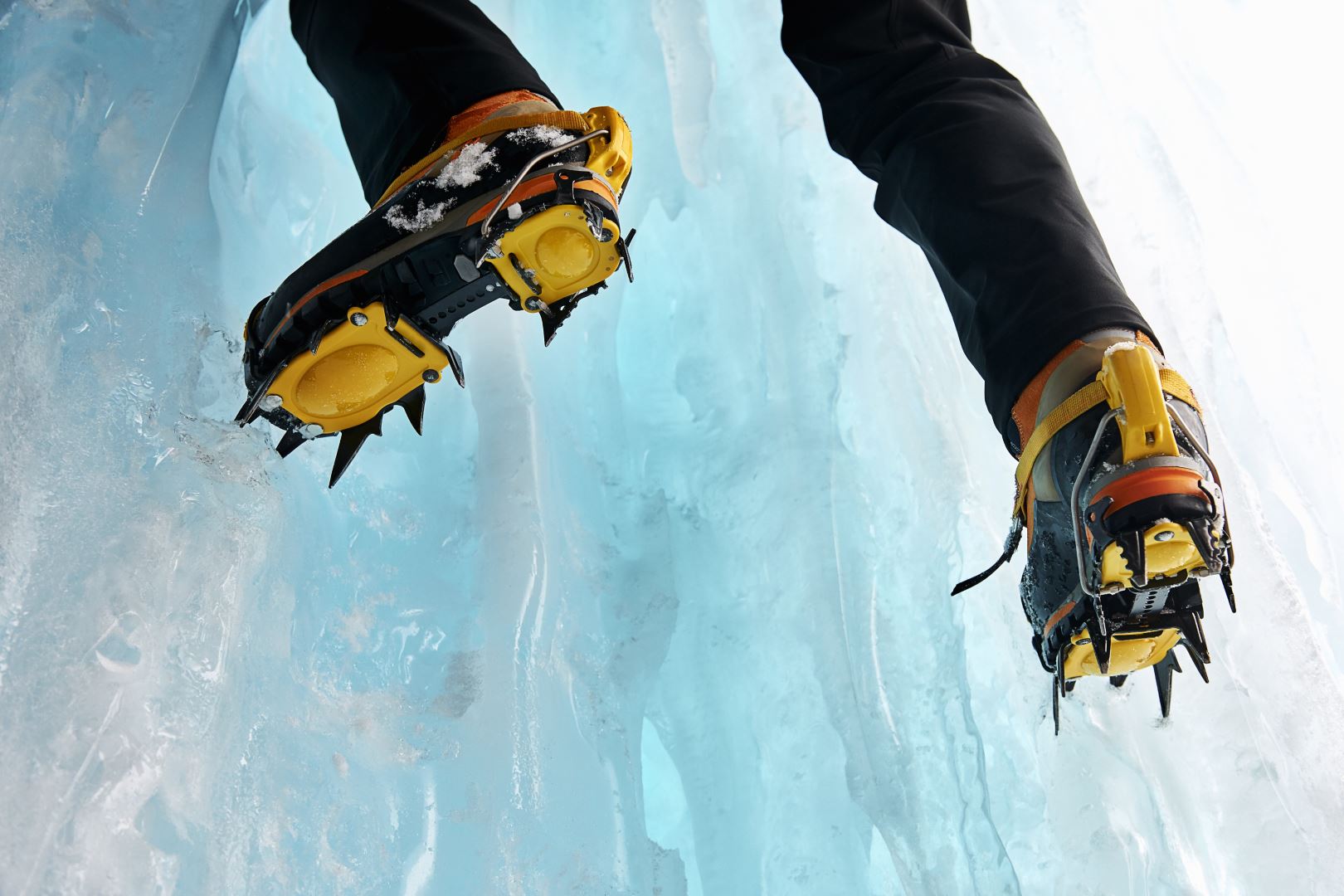 Cropped view of ice climbers feet wearing crampons