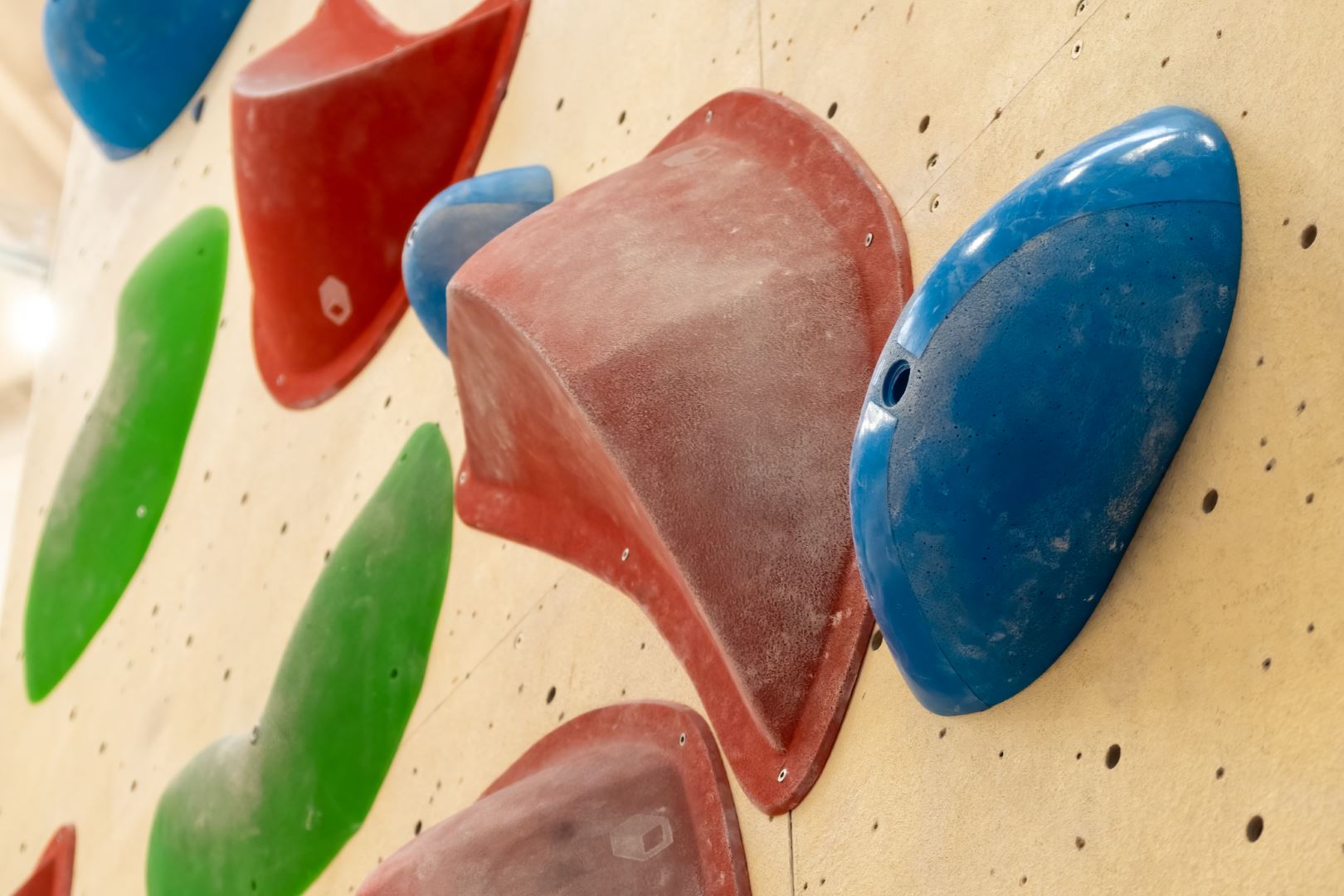 Stone hooks or grips on the artificial climbing wall in bouldering gym