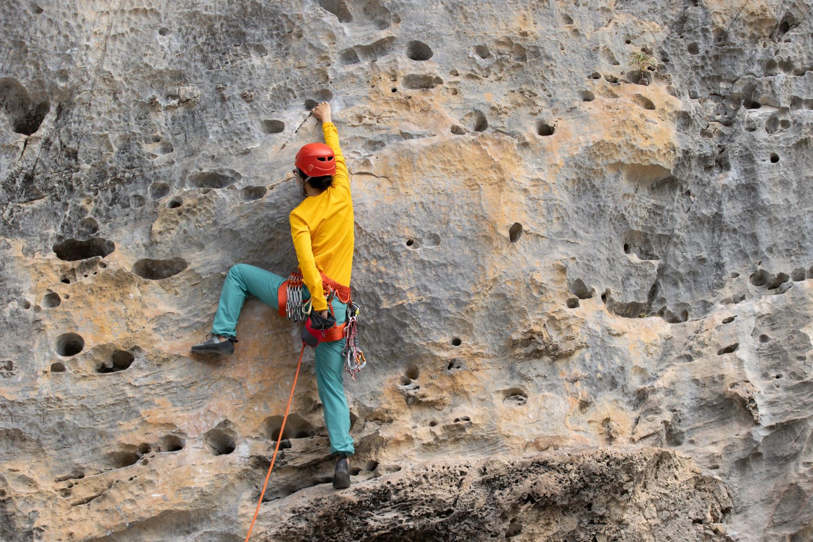 Woman rock climber climbing on the cliff